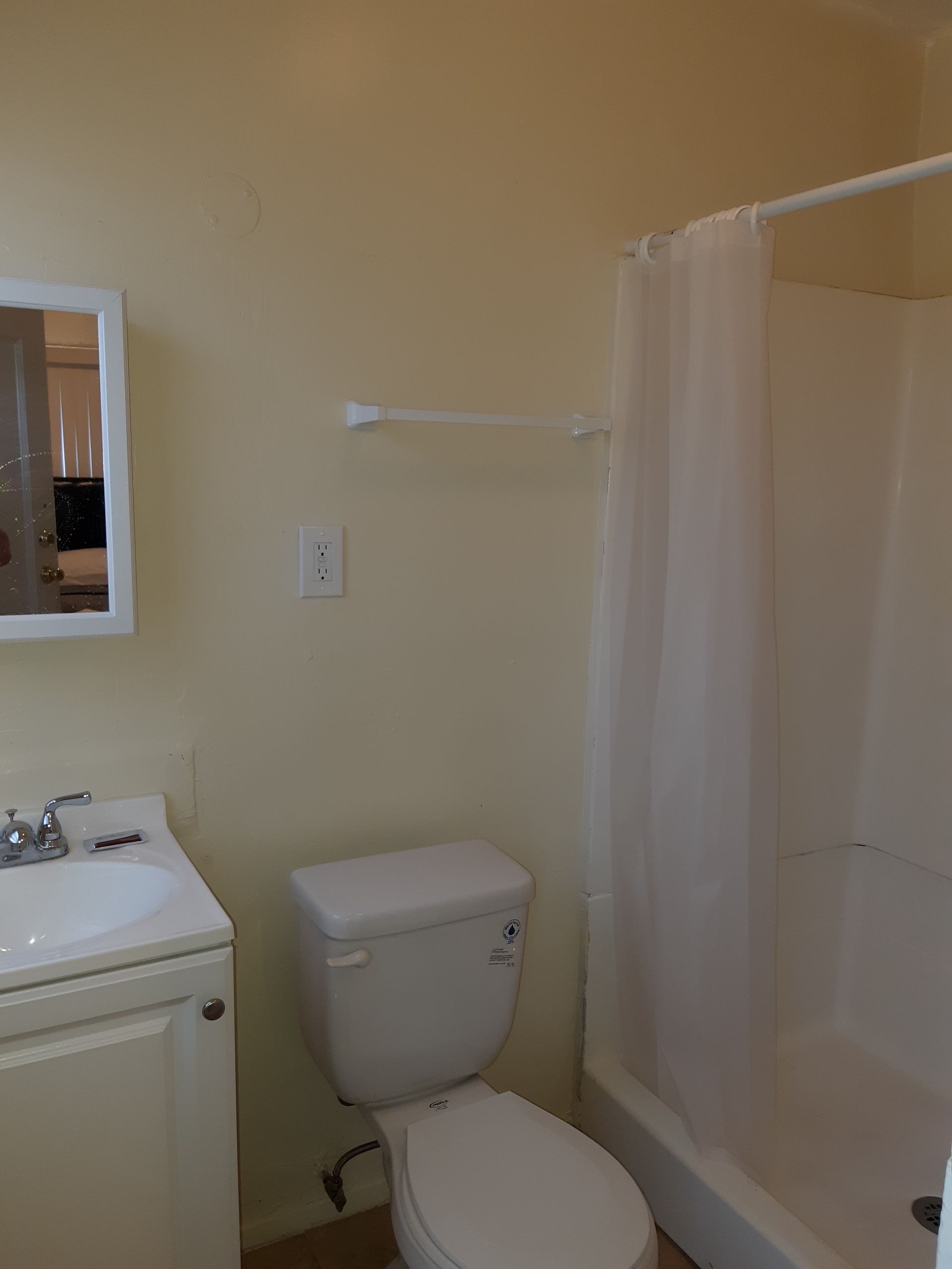 A bathroom with a toilet , sink , and shower.