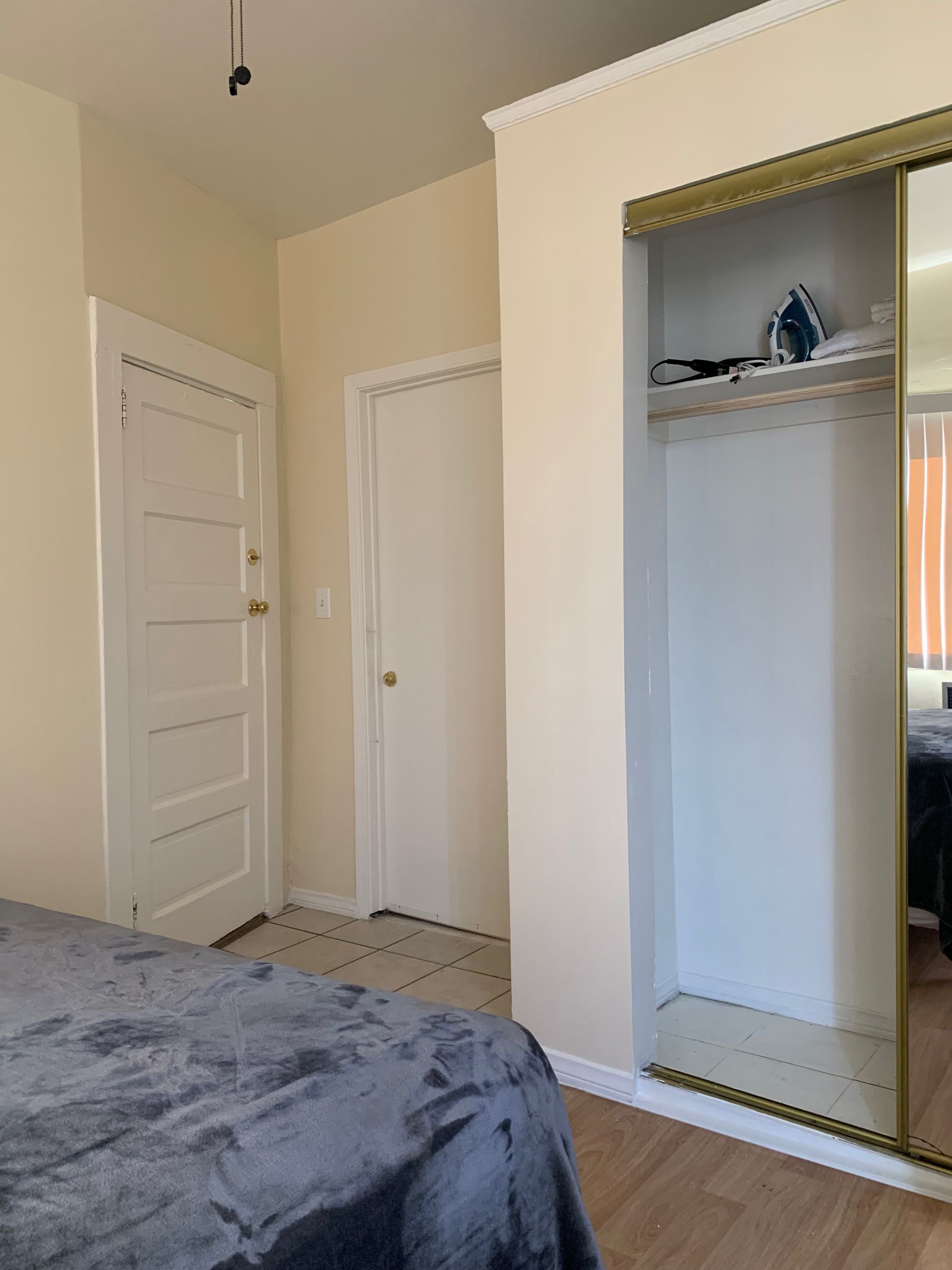 A bedroom with a bed , closet , and mirror.