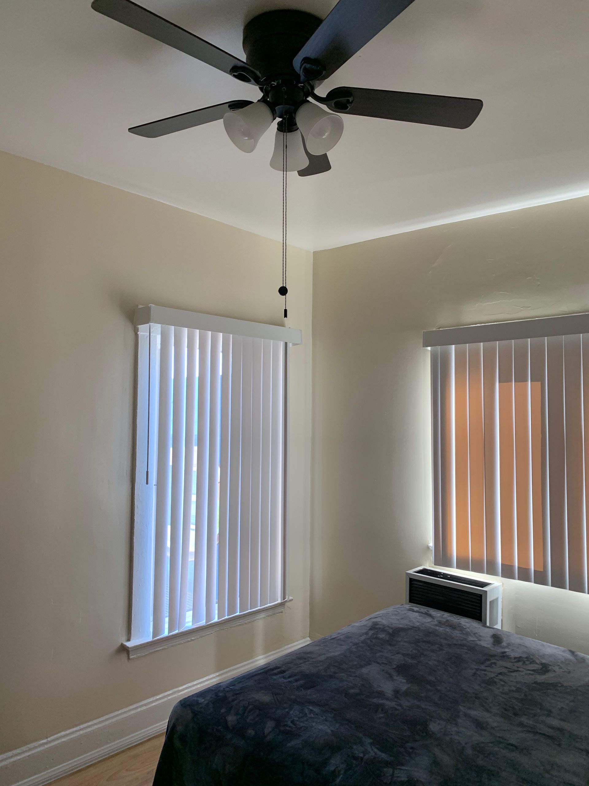A bedroom with a bed and a ceiling fan