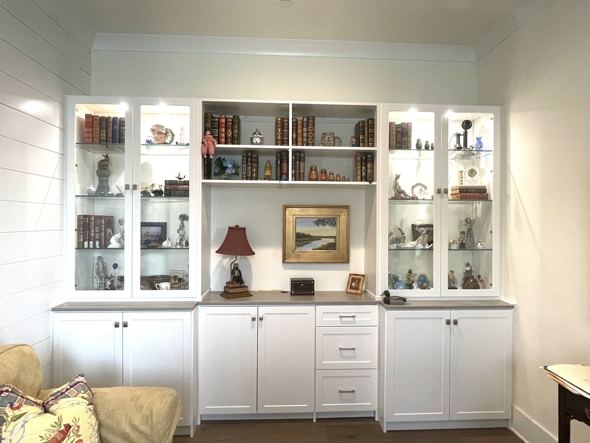 A living room with white cabinets and glass doors