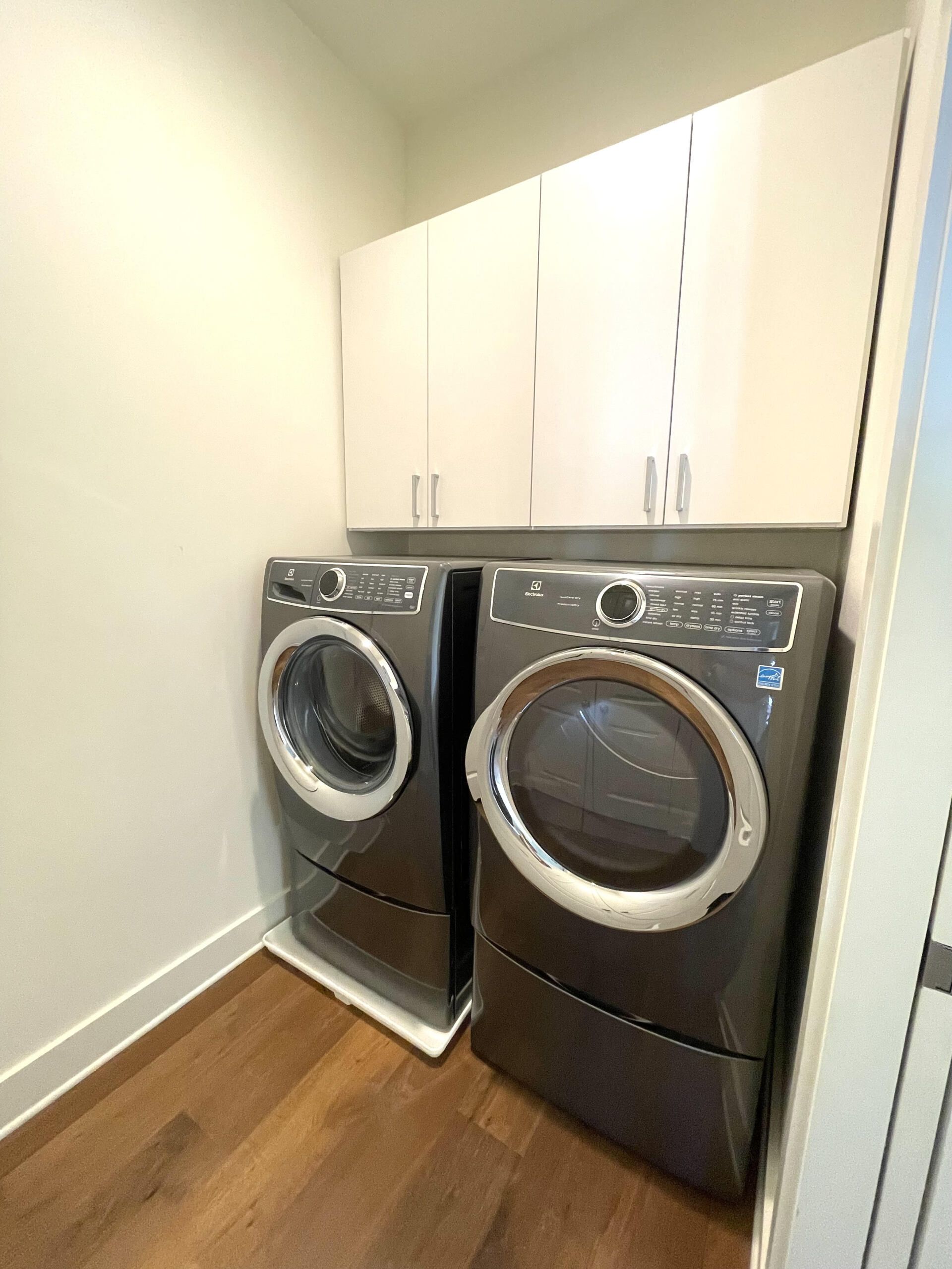 A laundry room with two washing machines and a dryer.