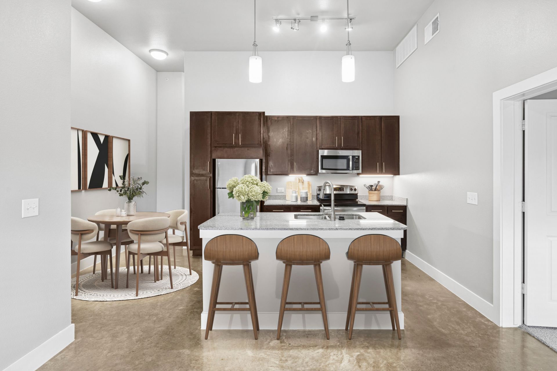 Modern kitchen with island, dark wood cabinets, and dining area.