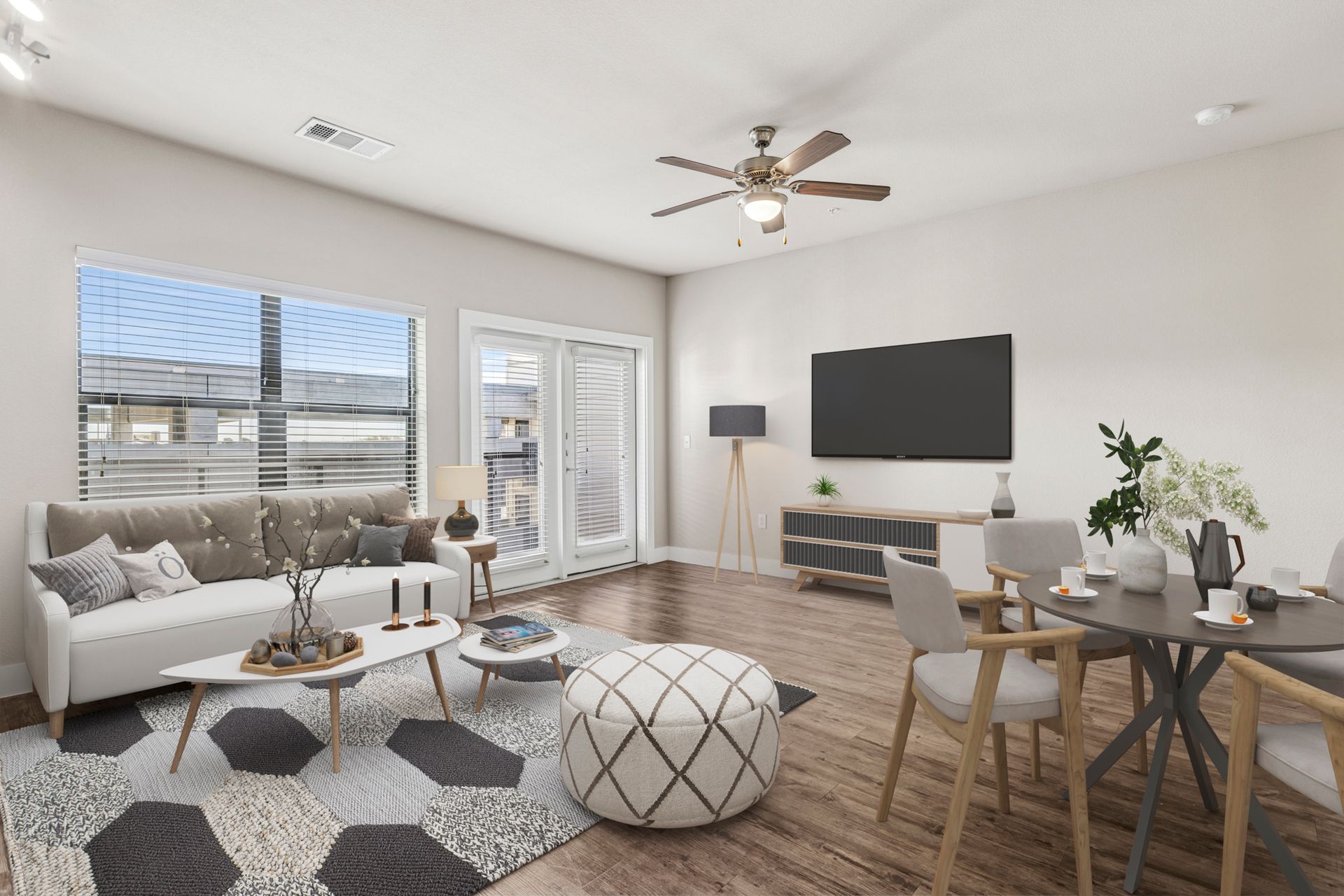 Living room with white walls, dark wood floor, windows, and modern furniture.