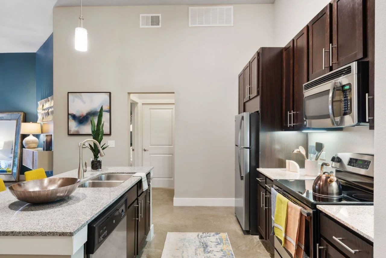 A kitchen with stainless steel appliances and granite counter tops.
