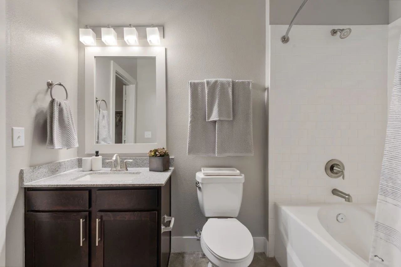 A bathroom with a toilet , sink , and bathtub.