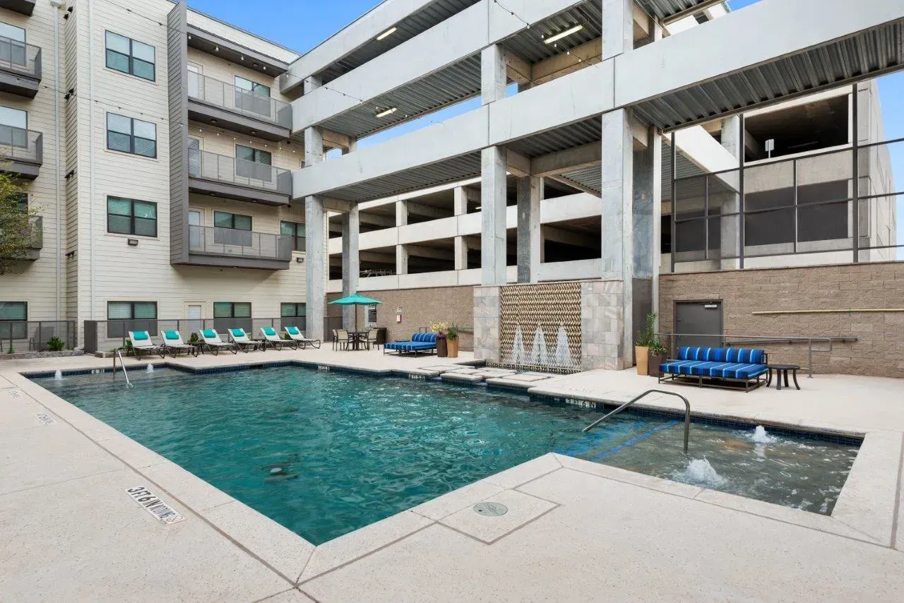 A large building with a swimming pool in front of it.