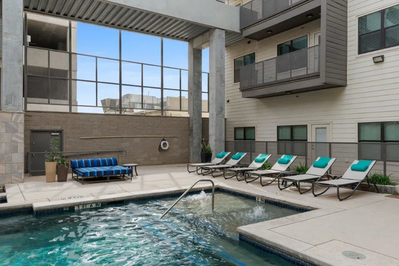 There is a large swimming pool in the middle of a building.