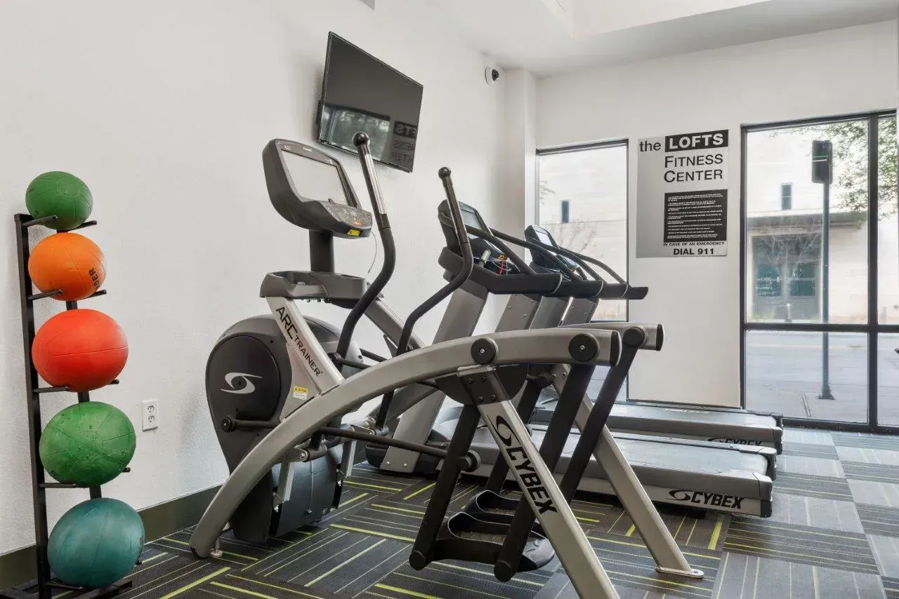A gym with treadmills , exercise bikes , and medicine balls.