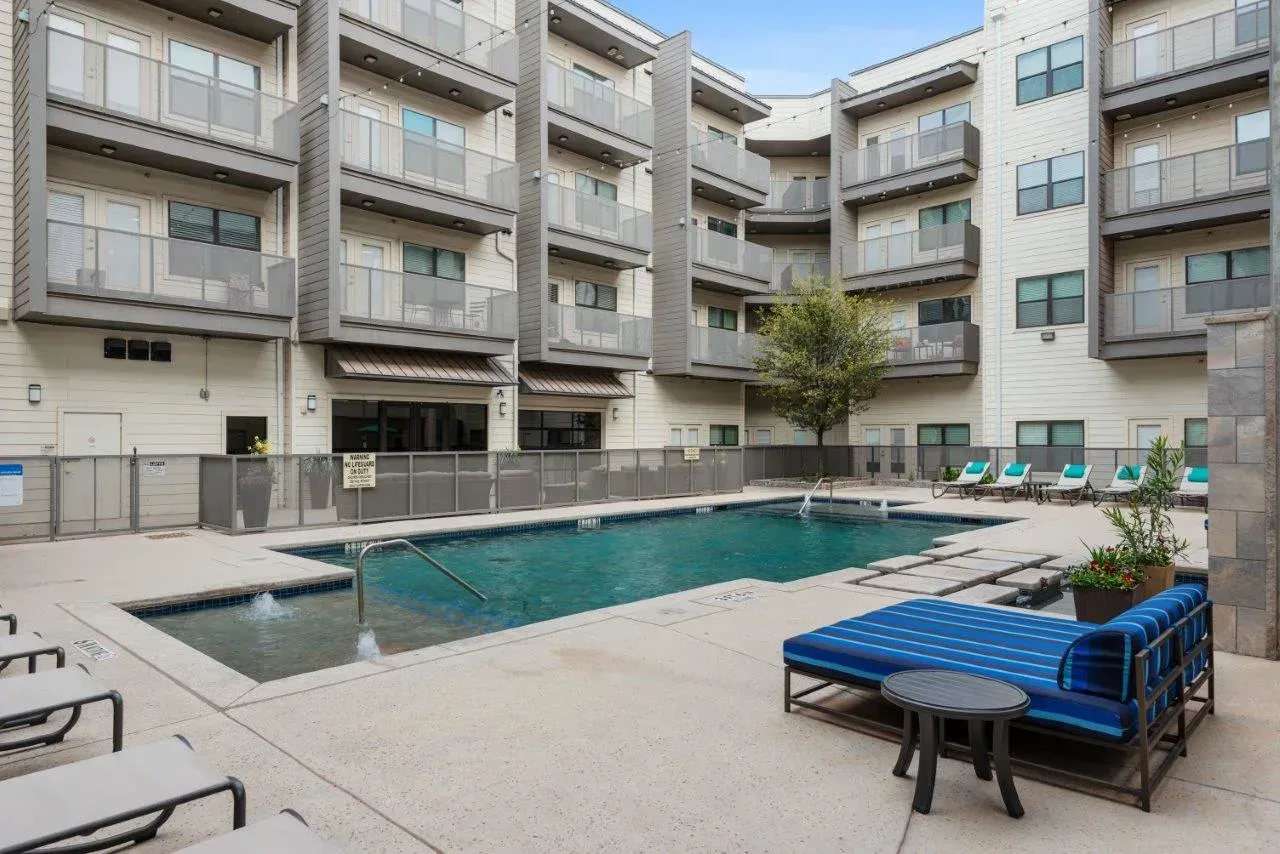 There is a large swimming pool in the middle of a building.
