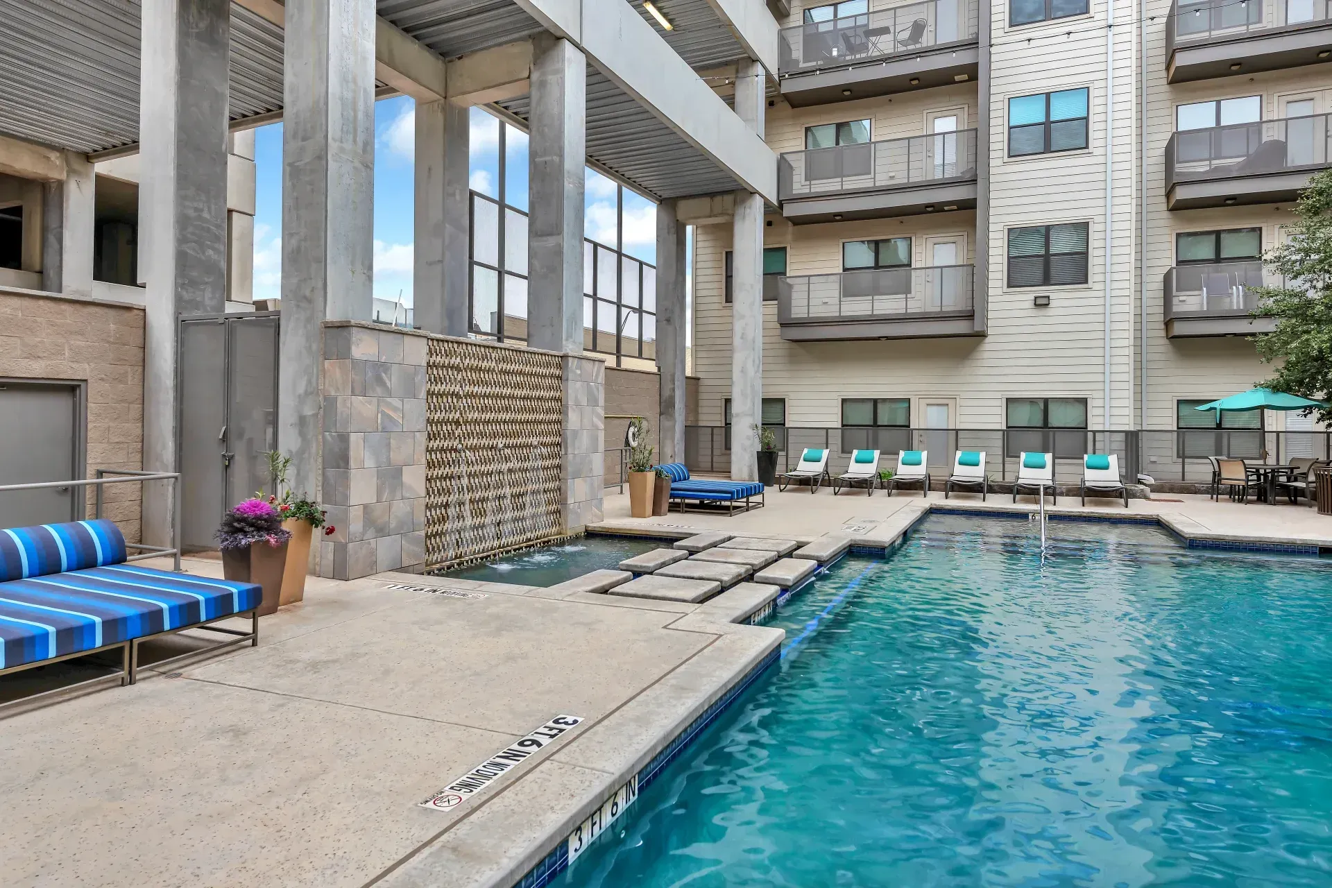 There is a large swimming pool in the middle of a building.