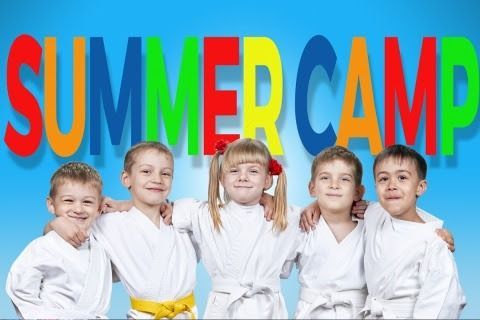 Five smiling children in white karate uniforms stand in a row against a blue background with multicolored