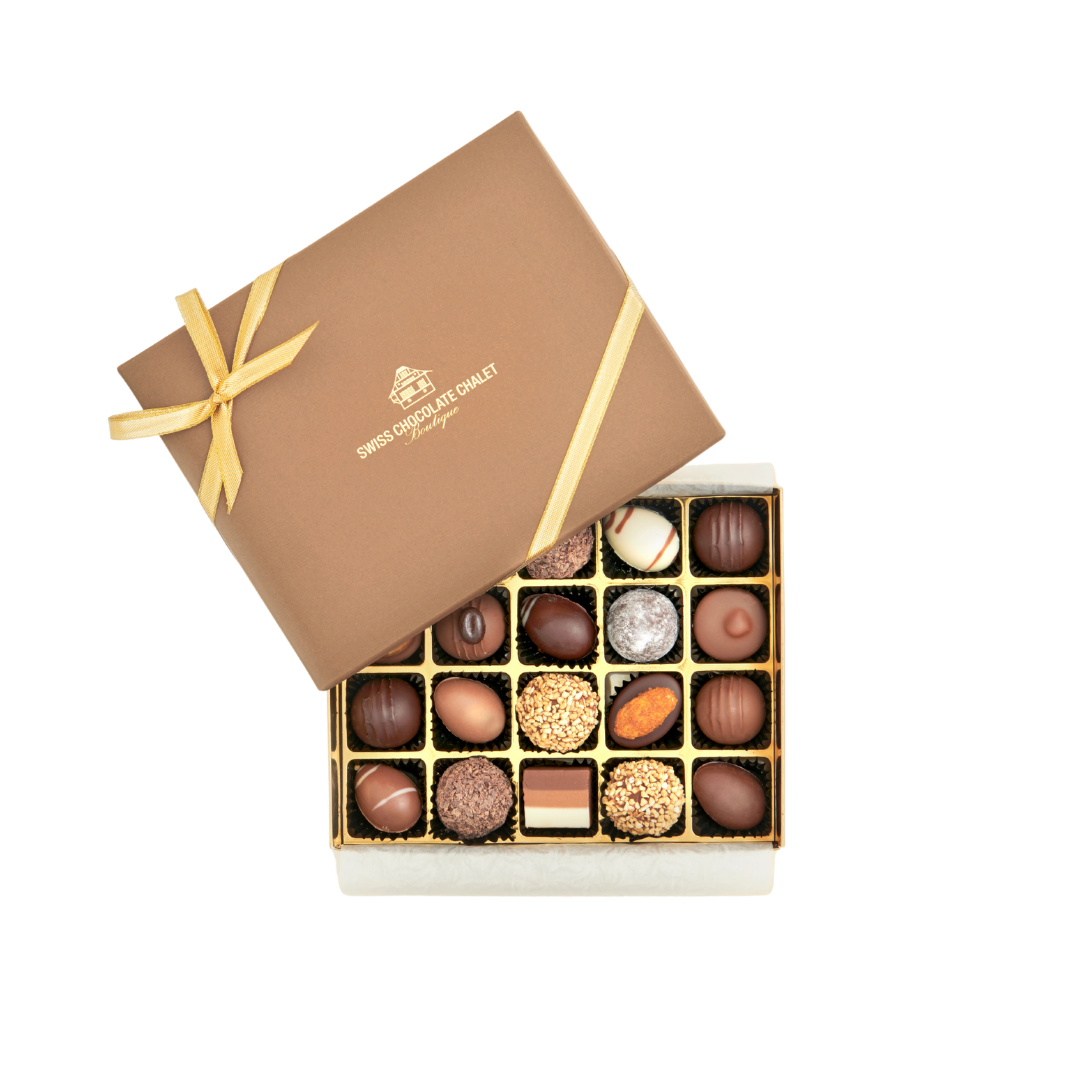 Schachtel mit gemischten Pralinen und braunem Band, der Deckel ist teilweise geöffnet und gibt den Blick auf ordentlich angeordnete Trüffel und Süßigkeiten frei