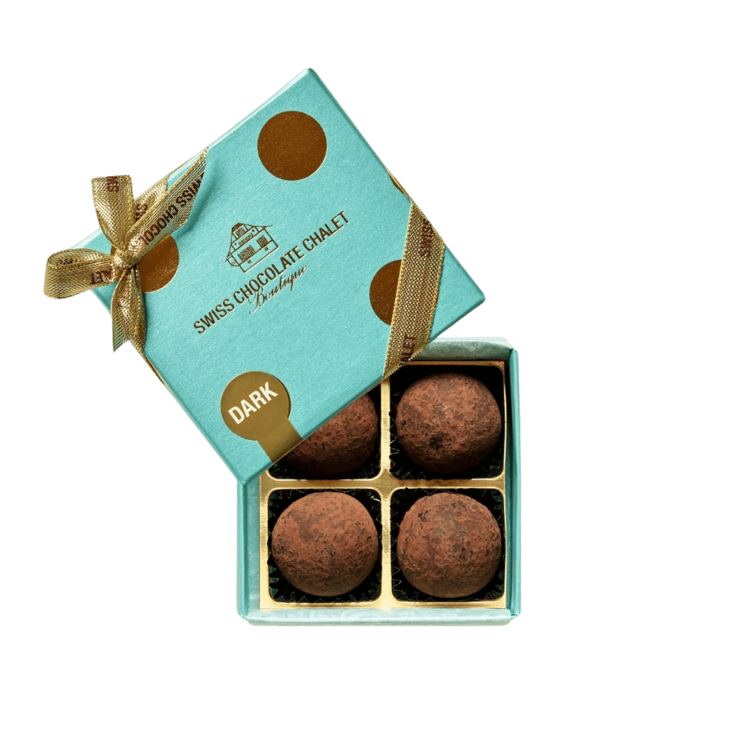 Türkisfarbene Geschenkbox mit Schleife, geöffnet, sodass vier runde Pralinen in einzelnen Fächern zu sehen sind