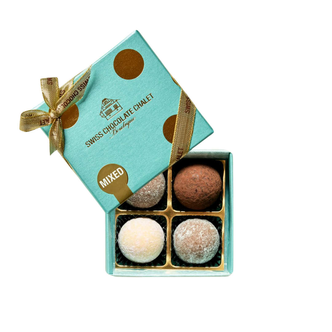Türkisfarbene Geschenkbox mit einer Auswahl an Pralinen und goldener Schleife, geöffnet, sodass vier Trüffel zu sehen sind.