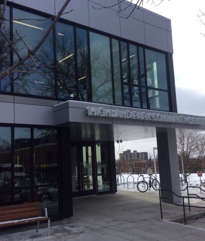 Highland Park Community Center entrance, glass windows, bike rack, snowy ground.