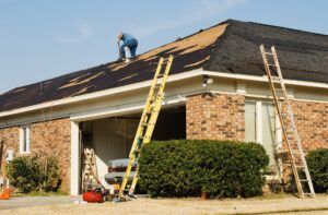 A man is working on the roof of a house.
