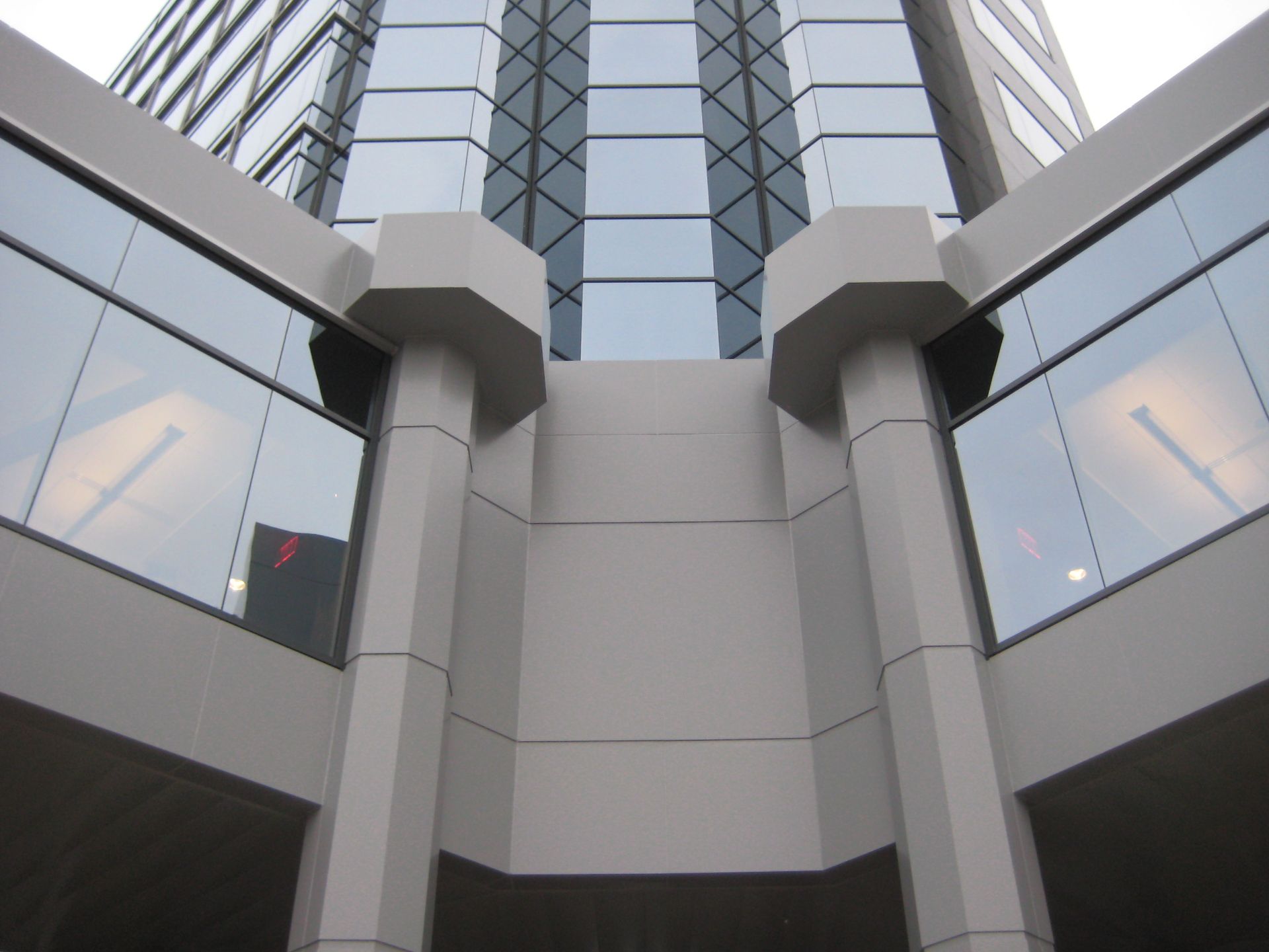 Gray modern building with geometric pillars and large windows.