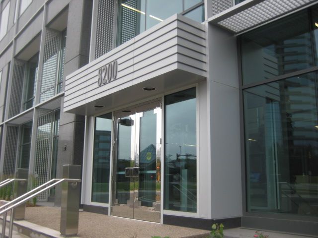 Building entrance with glass doors, silver trim, and 