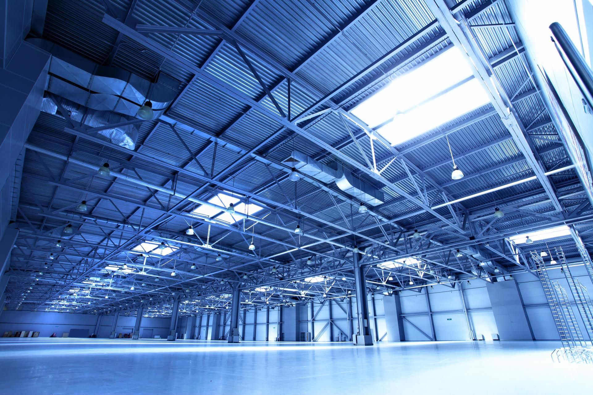 A large empty warehouse with a blue sky in the background.