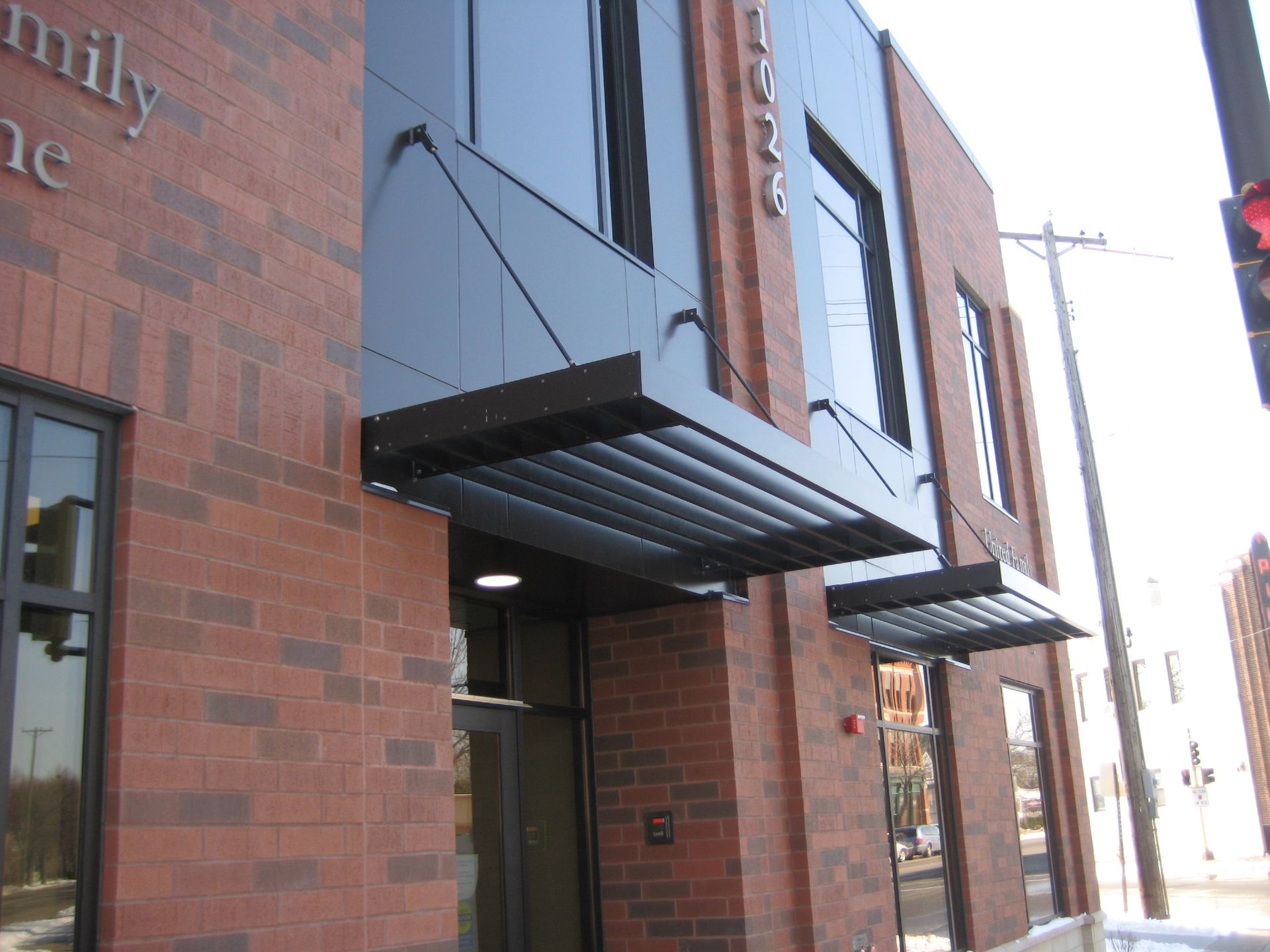Red brick building with black awning and window; the address 1036 is visible.
