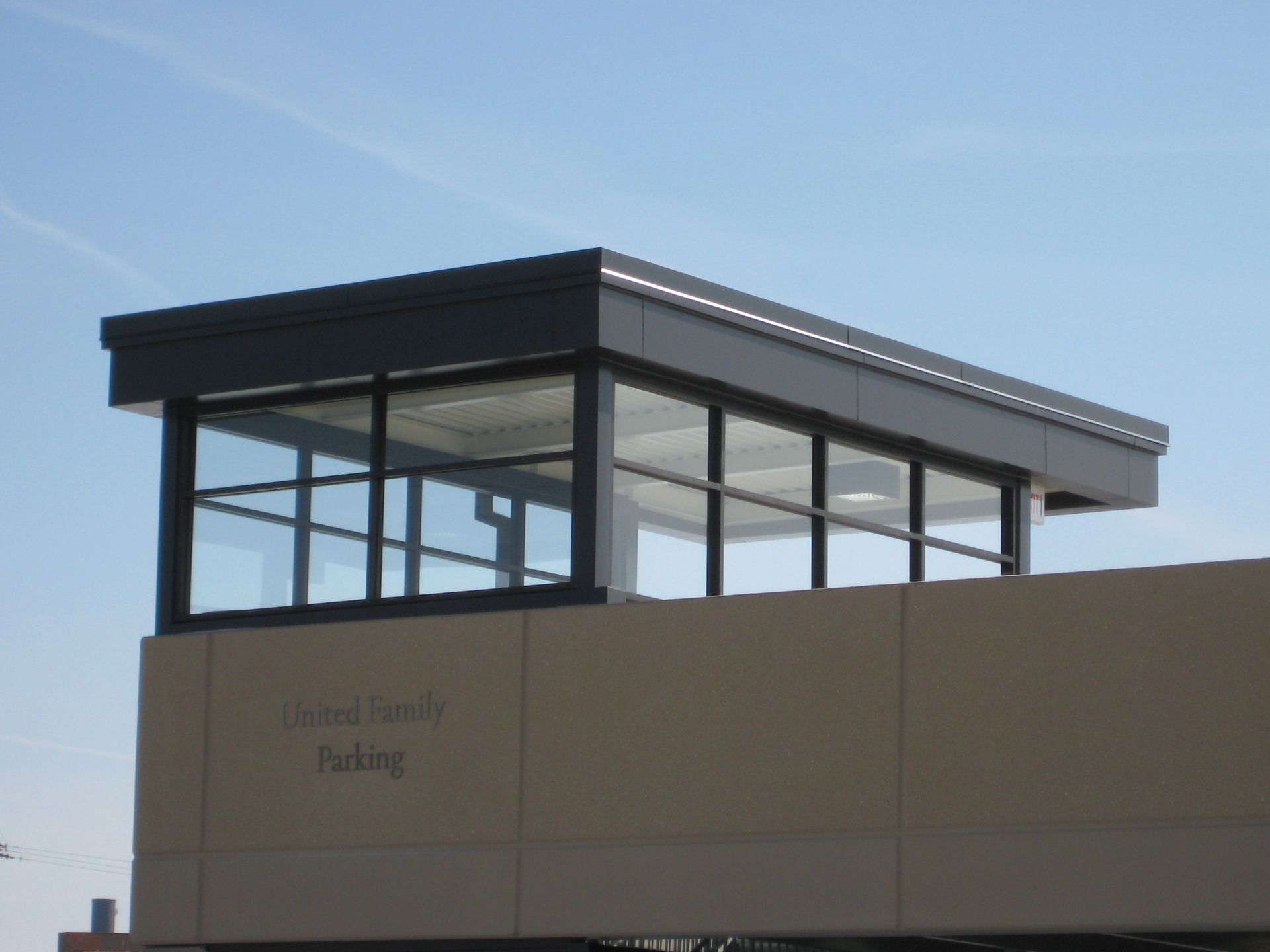 A modern building with a glass-walled structure atop, labeled 