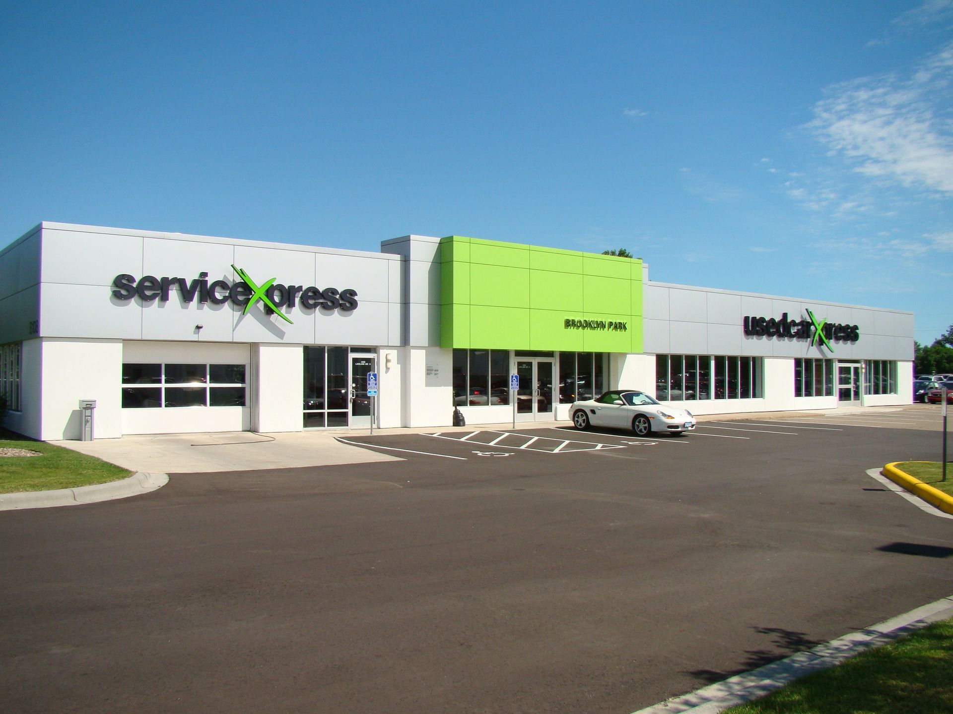 Exterior of Service Express building with green and silver accents, car parked out front.
