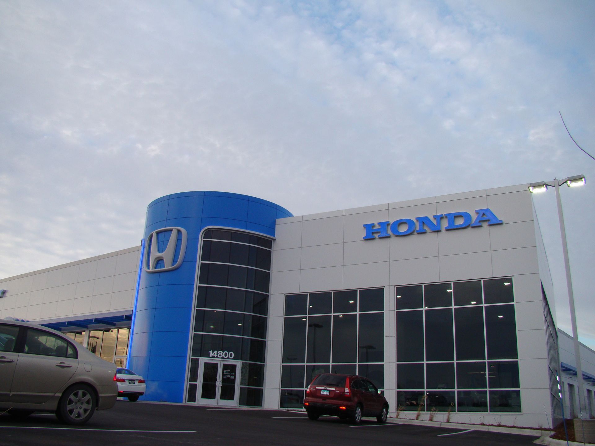 Honda dealership exterior with blue accents and cars.