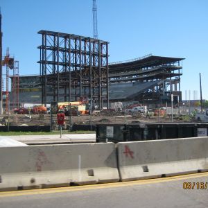 Construction site with a steel framework of a stadium on a sunny day.