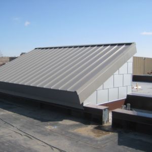 Metal roof structure on a flat roof, against a blue sky.