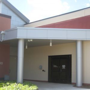 Building exterior with pillars, recessed entrance, and address 