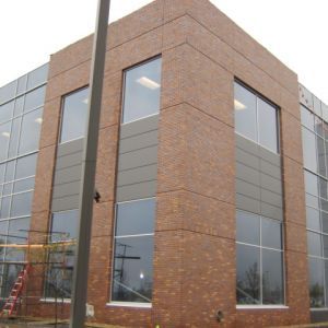 Brick and glass office building exterior with large windows.