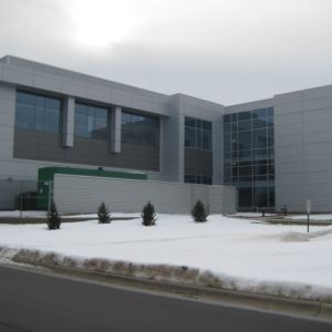Modern building with gray facade and large windows, surrounded by snow.