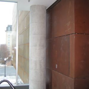 Concrete pillar next to a window with brown wall panels.