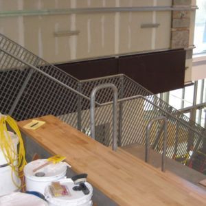 Staircase under construction with a wooden surface, metal railings, and tools.