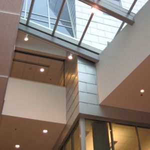 Interior view of a modern building atrium with glass ceiling and lights.