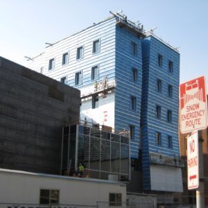 Building under construction, blue facade, windows, and 