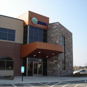 Modern office building with brick, stone, and bronze accents; 
