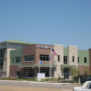 Anchor Bank building with brick, stone, and green accents; blue sky.