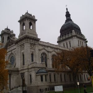 Exterior view of the Cathedral of Saint Paul in St. Paul, Minnesota, with stone facade and dome, under an overcast sky.