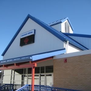 Graham Arena building with blue trim and sign, a red cross logo, and brick details.
