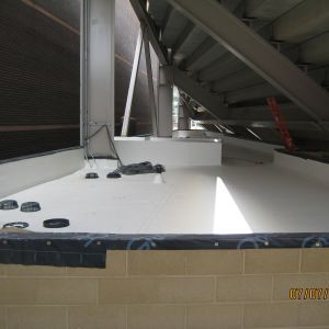 White waterproof coating within a structure with metal beams and brick wall.