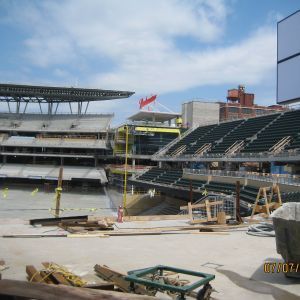 Baseball stadium under construction; rows of seats, unfinished structures, and equipment visible.