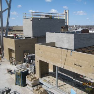 Construction site with concrete structures on a rooftop. Blue sky. Tools and materials are visible.