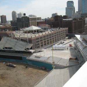 Construction site with parking garage and city buildings in the background.