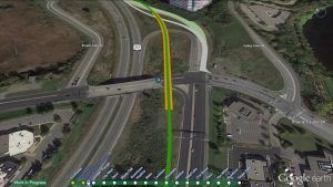 An aerial view of a highway intersection with a building in the background.