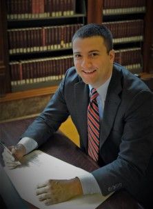 A man in a suit and tie is sitting at a desk