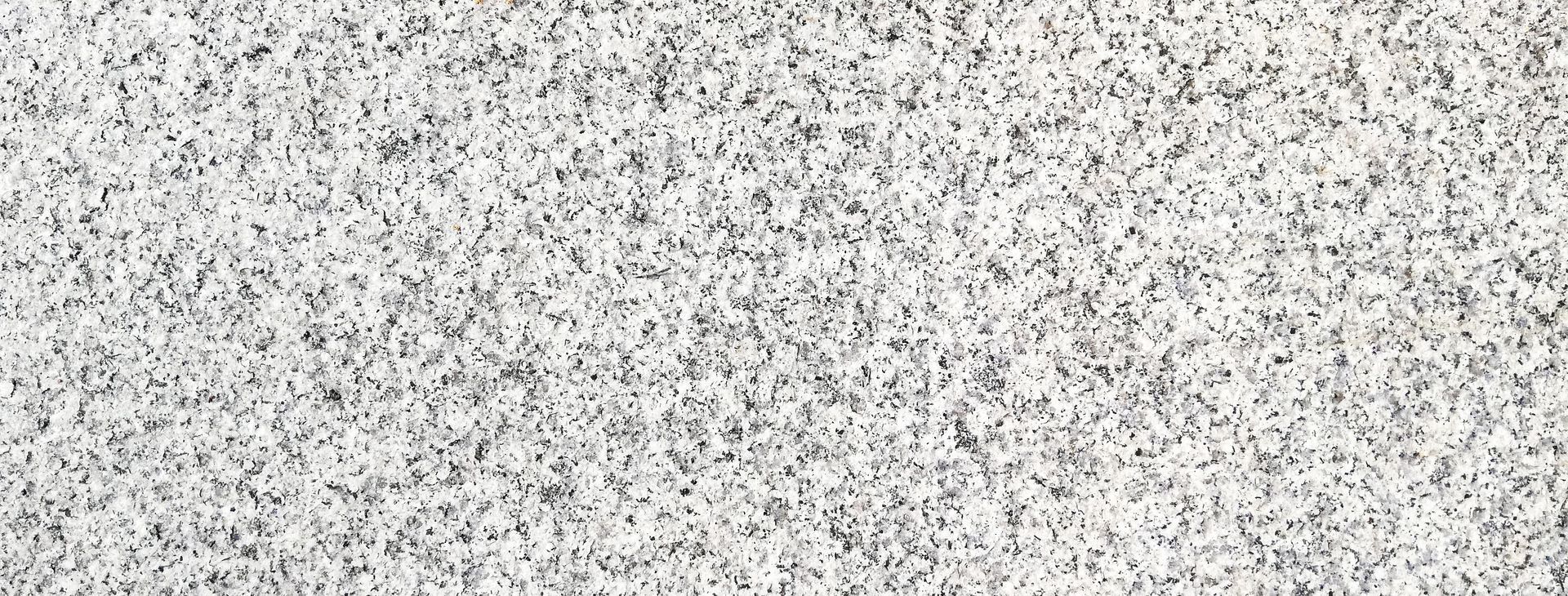 Texture de granit avec des motifs mouchetés gris et blancs.