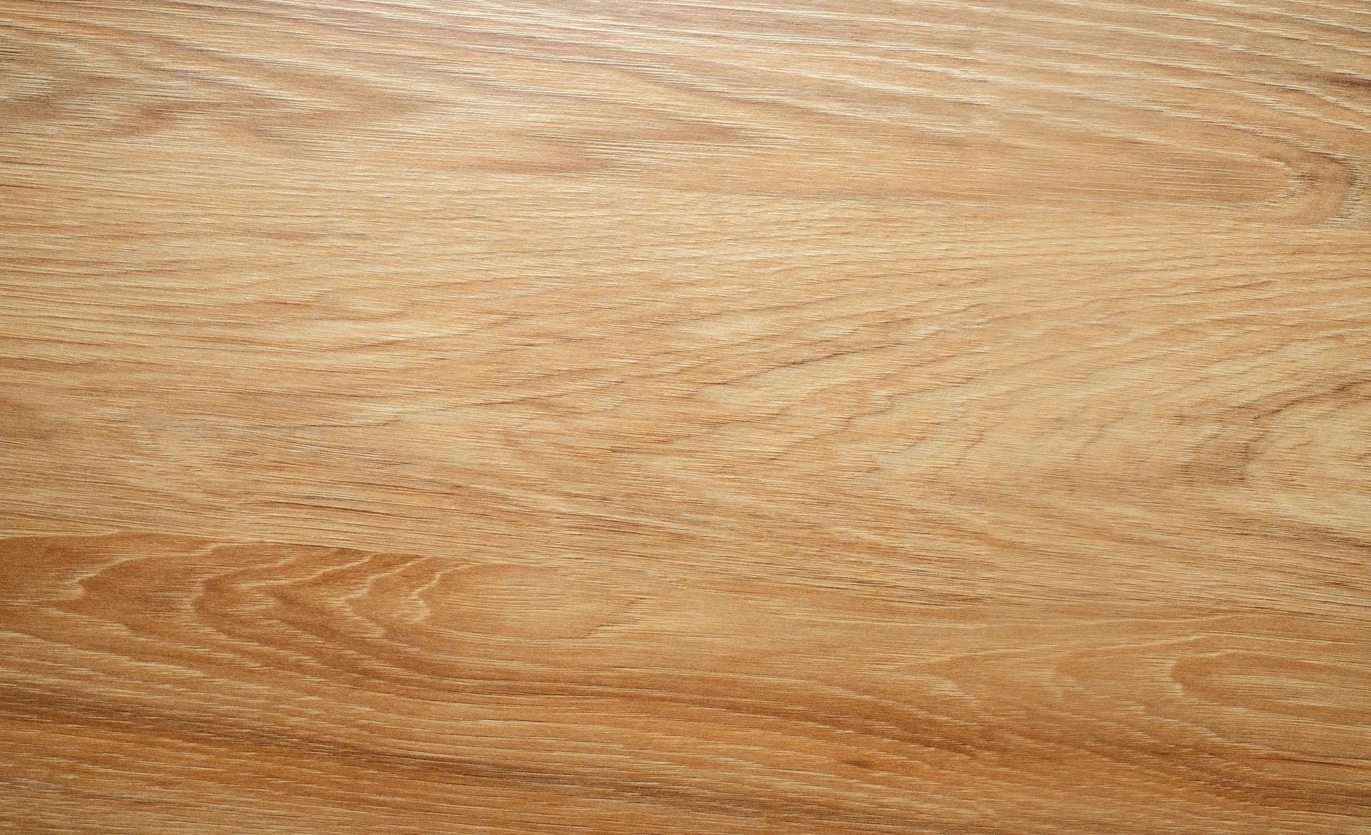 Gros plan du grain du bois brun clair avec des motifs tourbillonnants.