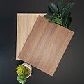 Deux planches de bois, une claire, une foncée, avec de la verdure sur une surface sombre.