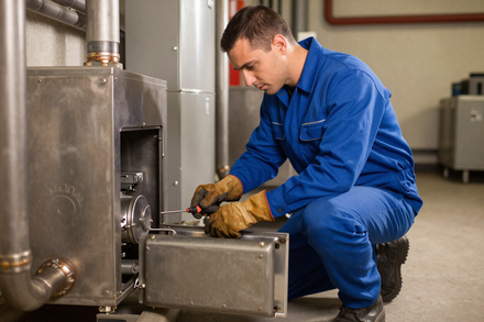 Worker repairing an electrical outlet Technician servicing an HVAC unit